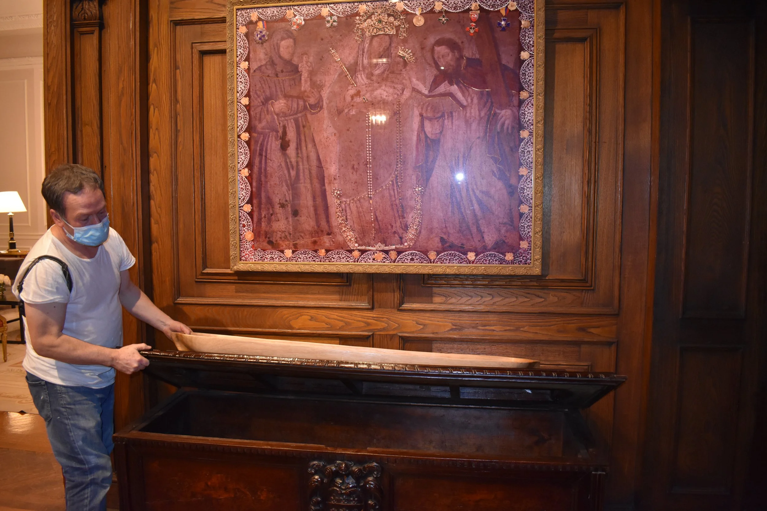 The home's caretaker, John, shows off a piece of antique furniture original to the house. Photo by Diplomatica Global Media.