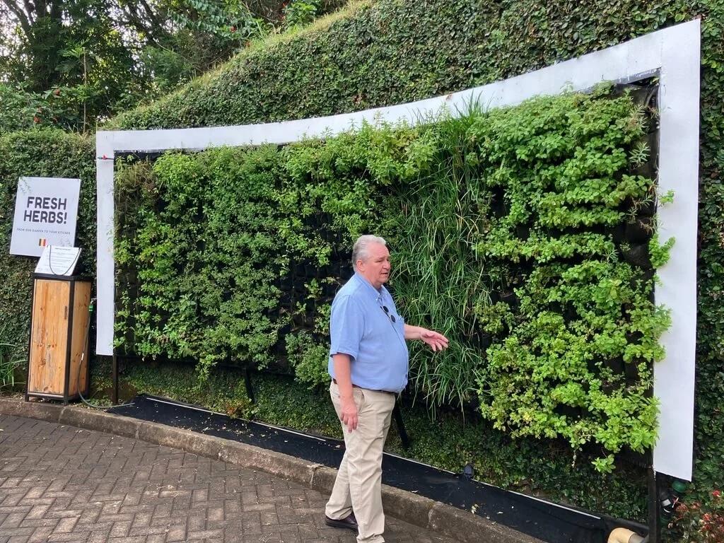 Ambassador Peter Maddens in front of a vertical hydroponic herb wall that acts as a tool of environmental diplomacy. Photo by Diplomatica Global Media.   