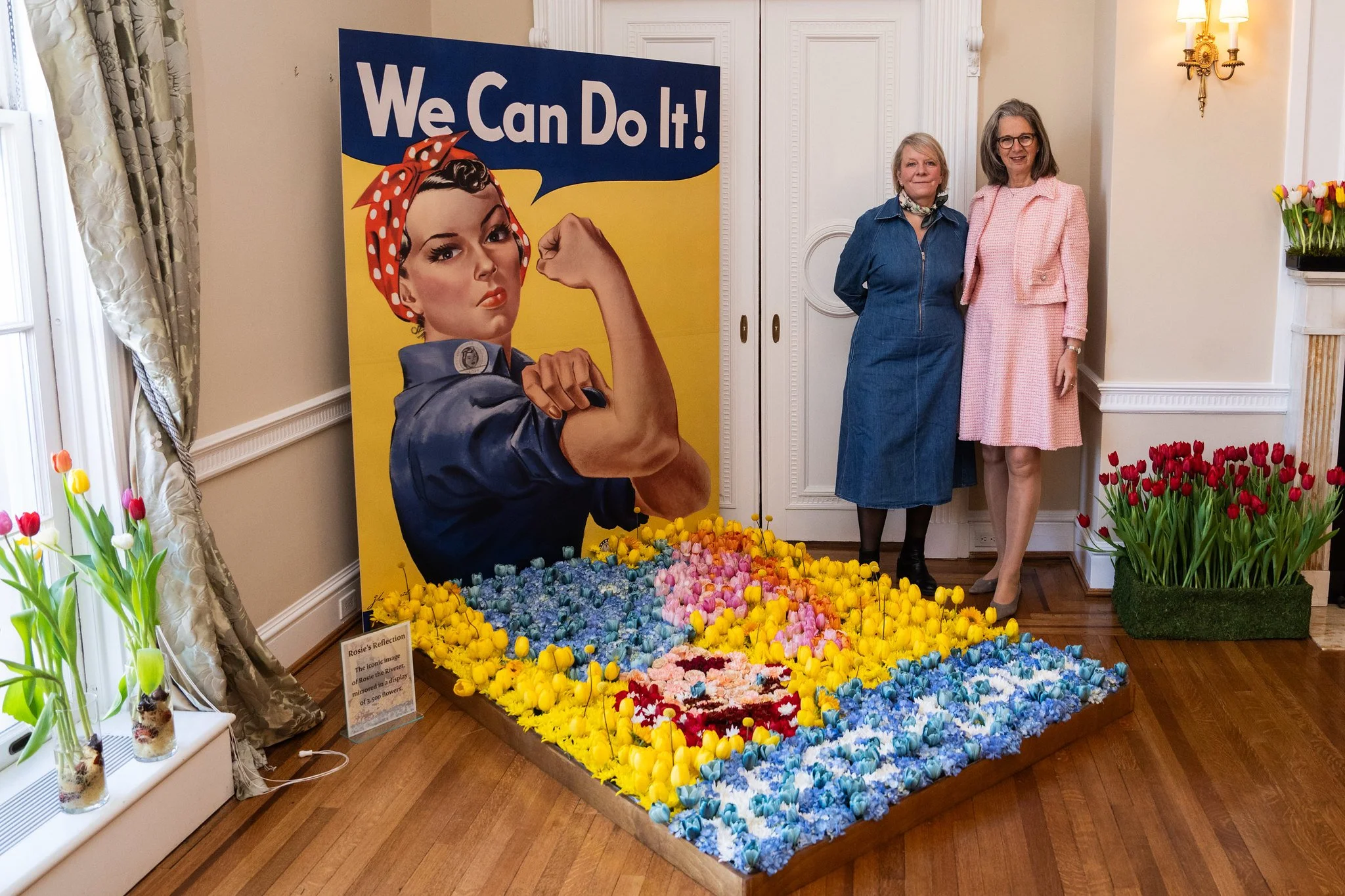 Dutch Ambassador Birgitta Tazelaar and florist Susanne Schrijvers stand by a tribute to Rosie the Riveter. Photo courtesy of the embassy.