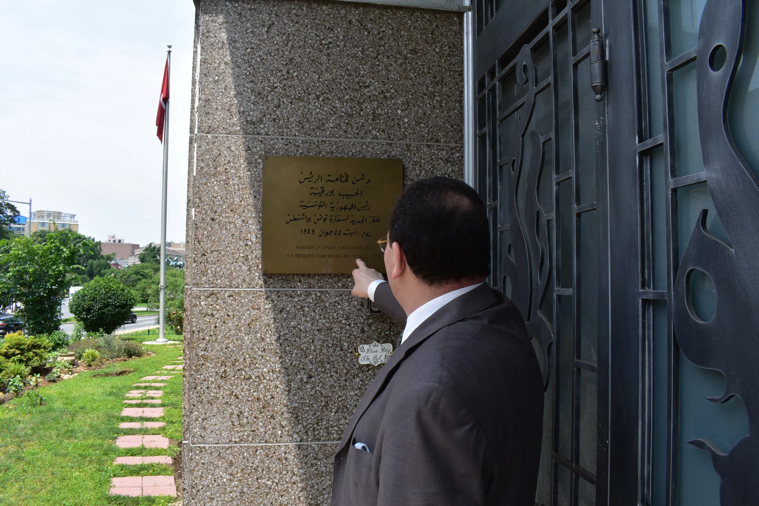 Ambassador Gouia points to a plaque commemorating the inaguration of the embassy. Photo by Diplomatica Global Media.